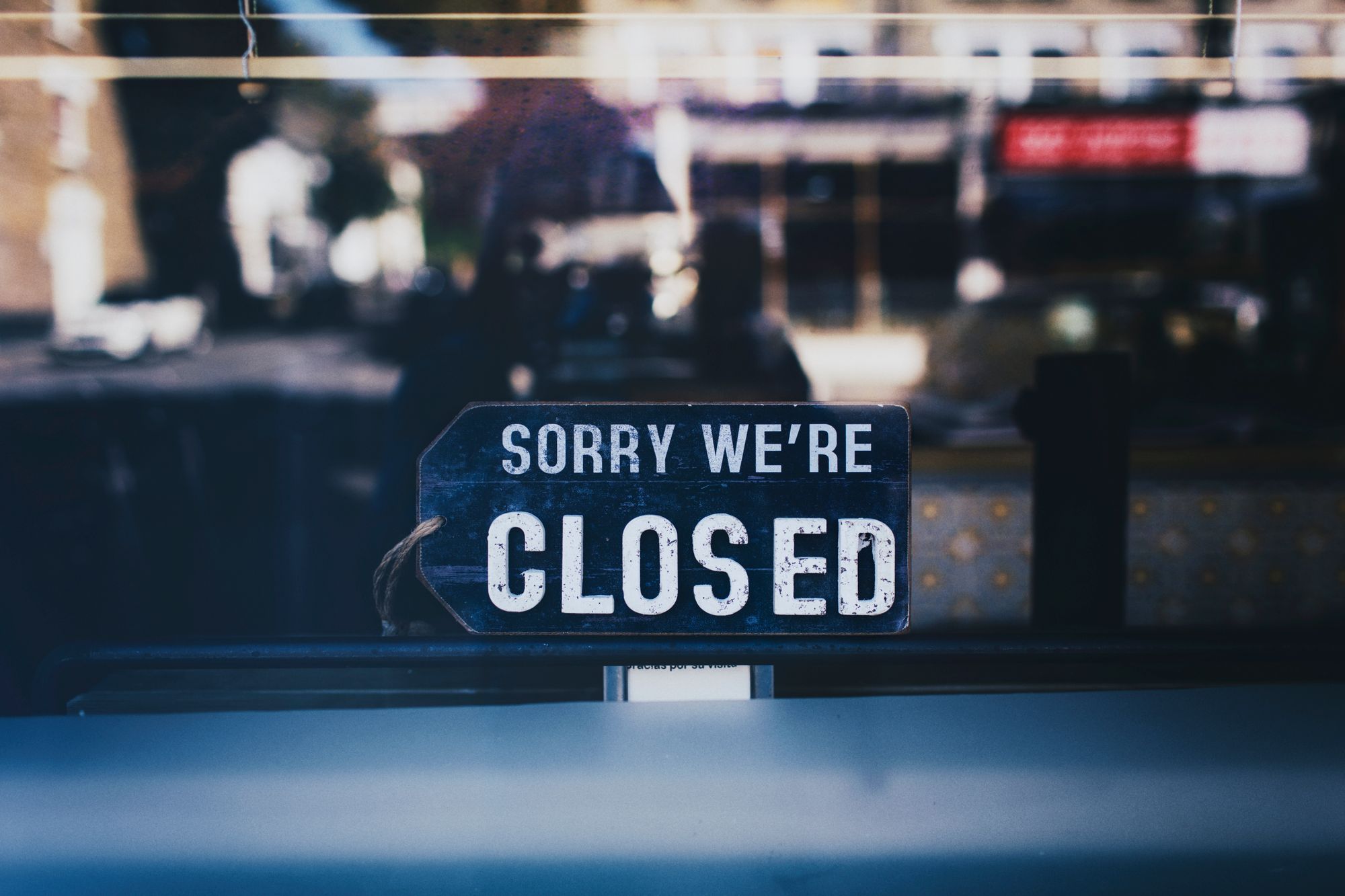 Sorry We're Closed sign propped in the window of a darkened shop, the scene owners fear when the rent falls behind